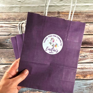 Unicorn personalised paper party bags x 5 in purple. Eco-friendly, compostable, plastic free and FSC certified twisted paper handles.