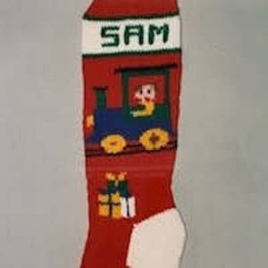 May include: Red and white knitted Christmas stocking with a blue and green train design and the name "SAM" embroidered on the cuff.