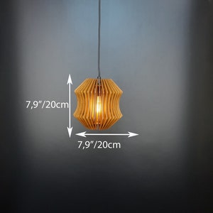 May include: A wooden pendant light with a geometric design. The light is 20cm in diameter and is hanging from a black cord.