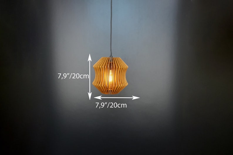 May include: A wooden pendant light with a geometric design. The light is 20cm in diameter and is hanging from a black cord.