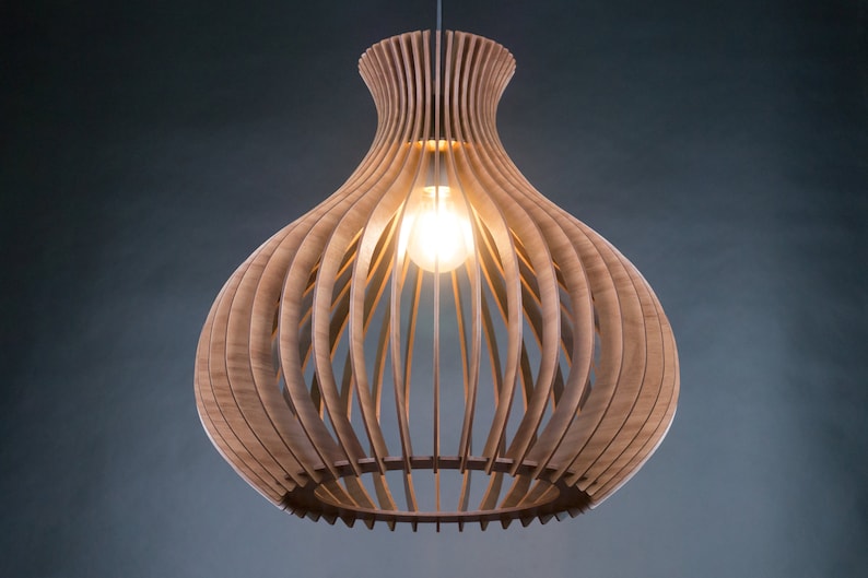 May include: A wooden pendant light fixture with a bulb. The light has a unique design, with vertical wooden slats forming a bulbous shape. The light fixture is suspended from a wire and emits a warm glow.