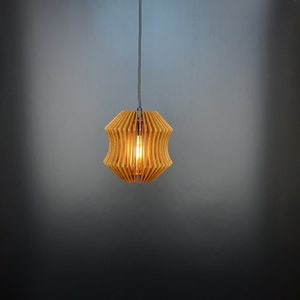 May include: A wooden pendant light with a geometric design. The light is hanging from a ceiling and is turned on, illuminating the room.