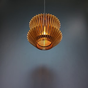 May include: A wooden pendant light fitting with a geometric design. The light is on and casts a warm glow.