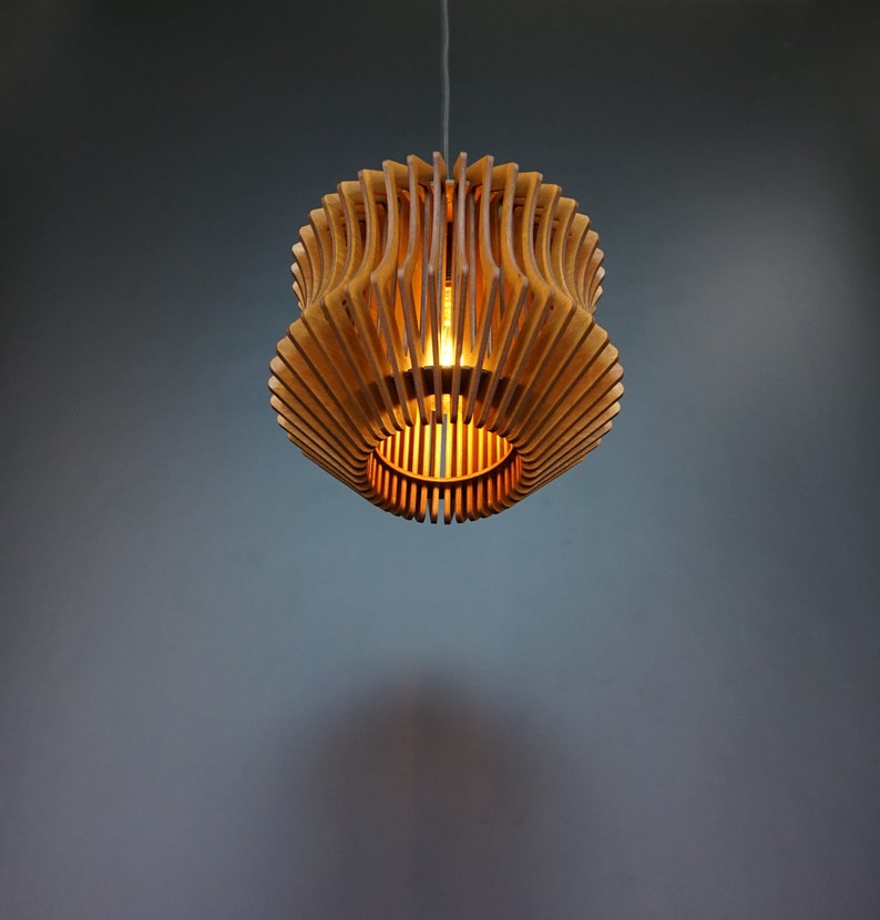 May include: A wooden pendant light fitting with a geometric design. The light is on and casts a warm glow.
