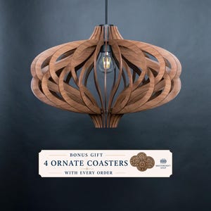 Op de afbeelding: Een hanglamp opgebouwd uit gebogen bruine houten latten in een bolvormig, open frameontwerp met een centrale gloeilamp. Daaronder staat een rechthoekig label met de tekst: BONUS GIFT 4 ORNATE COASTERS WITH EVERY ORDER MASTERCRAFT SHOP.