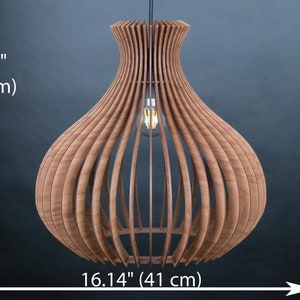 May include: A wooden pendant light fixture with a bulb, 16.14 inches (41 cm) in height and width. The light has a unique, open design with vertical wooden slats, creating a warm, ambient glow. The fixture is suspended from a black cord.