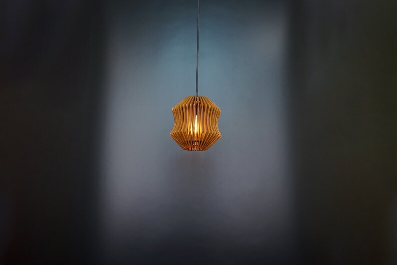 May include: A wooden pendant light with a geometric design. The light is on and casts a warm glow.