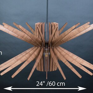 K&ouml;nnte beinhalten: Eine Deckenleuchte aus Holz mit einem Sternburst-Design. Die Leuchte ist 60 cm breit und 30 cm hoch.