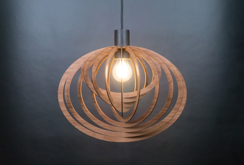 Puede incluir: Una l&aacute;mpara colgante moderna de madera con un dise&ntilde;o circular. La l&aacute;mpara tiene un acabado de madera natural c&aacute;lido y una sola bombilla.