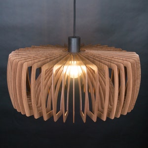 May include: A modern, wooden pendant light fixture with a circular, fan-shaped design. The light is made of thin, layered wood strips that create a unique and intricate pattern. The light is illuminated by a single light bulb.