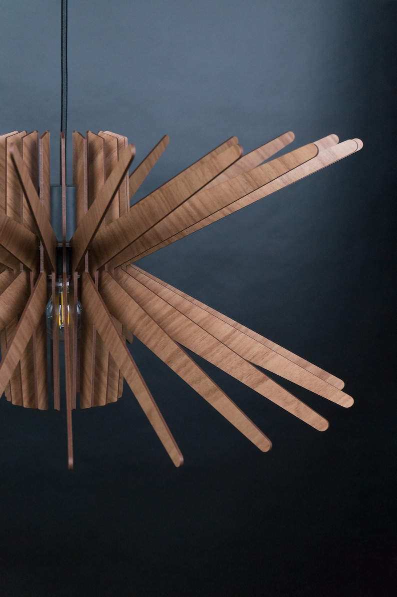 May include: A wooden ceiling light fixture with a circular base and multiple wooden slats extending outwards, creating a starburst pattern.