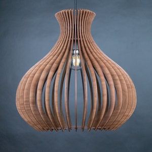 May include: A wooden pendant light fixture with a bulb. The light has a unique design, with vertical wooden slats forming a bulbous shape. The light fixture is suspended from a black cord against a dark gray background. The light bulb is visible inside the fixture.