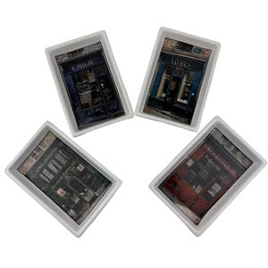 May include: Four rectangular white ceramic trays with images of French storefronts. Each tray features a different shop: "Emilie", "Livres", "Cafe Jerome Restaurant", and "Vins de Bourgogne". The shop fronts are depicted in shades of blue, red, and brown.