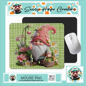May include: A rectangular mouse pad with a green grid background featuring a gnome wearing a pink hat, surrounded by pink and white flowers, holding a small basket. The text Sassy Hippo Creations appears on the packaging along with a white computer mouse.