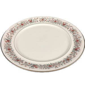 May include: Oval serving platter with a cream-colored center and a floral border. The border features pink, green, and white flowers and foliage. A thin gold band lines the edge of the platter, adding a touch of elegance.
