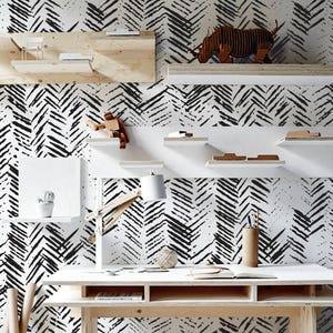 Puede incluir: Papel tapiz con patrón de chevron blanco y negro con un escritorio de madera, estantes y un taburete. El texto "Buy on patternsColoray Etsy Shop" es visible en la esquina inferior derecha de la imagen.