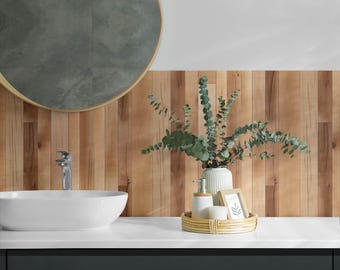 May include: A bathroom vanity with a white porcelain sink and a round mirror with a gold frame. The vanity is topped with a white countertop and a wooden backsplash. A wicker tray holds a white vase with green eucalyptus branches, a white soap dispenser, and a white jar.