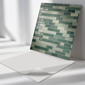 May include: A sheet of peel and stick tile backsplash with a green and white brick pattern. The tile is shown on a white surface.