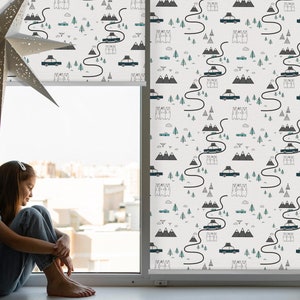 Może przedstawiać: Biała roleta okienna z powtarzającym się wzorem czarnych samochodów, zielonych drzew i szarych gór. Wzór jest na białym tle.