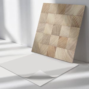 May include: A sheet of self-adhesive wood-look contact paper with a light brown wood grain pattern. The paper is partially peeled back to reveal the adhesive backing.