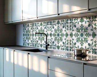May include: A modern kitchen with white cabinets and a black faucet. The backsplash is a white tile with a green floral pattern.