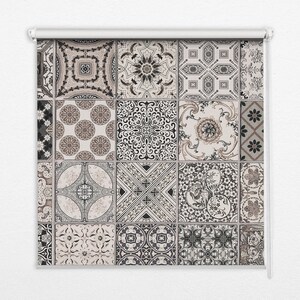 May include: Roller blind with a repeating pattern of decorative tiles in beige, brown, and black. Each tile features a unique floral or geometric design. The blind is mounted on a white roller mechanism.