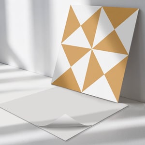 May include: A white tile with a geometric pattern of mustard yellow triangles. The tile is shown next to a plain white tile.