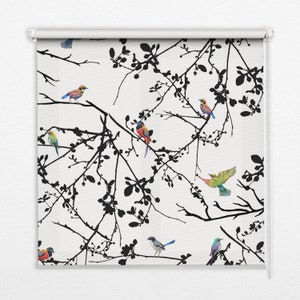 May include: A white roller blind featuring a black silhouette of branches and colourful birds. The birds are in various poses, including flying, perched, and singing.