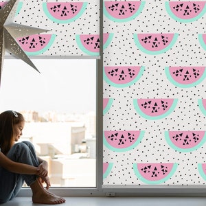 Peut inclure: Une fenêtre avec un fond blanc et des pois noirs. La fenêtre est recouverte d'un store enrouleur avec un motif répété de tranches de pastèque roses avec des pépins noirs et un contour bleu clair.