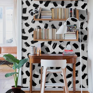 Puede incluir: Una pared blanca con un papel tapiz de patr&oacute;n de pinceladas en blanco y negro. Tres estantes de madera con libros est&aacute;n montados en la pared. Una l&aacute;mpara de escritorio blanca est&aacute; en el estante inferior. Una silla blanca y un escritorio de madera est&aacute;n frente a la pared. Una planta verde est&aacute; en una maceta marr&oacute;n en el suelo. El texto "Buy on patternsColoray Etsy Shop" est&aacute; en el suelo.