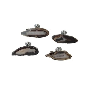 May include: Four decorative cabinet knobs with natural agate stone faces. The knobs have a silver-colored metal base and a unique, organic shape. The agate stones feature brown, white, and gray color variations.