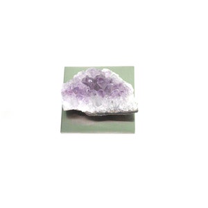 May include: A purple amethyst crystal cluster on a silver background.