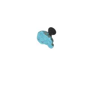 May include: A turquoise-colored shoe charm with a black stem. The charm has a unique, irregular shape and is designed to be attached to footwear. The turquoise color is a vibrant accent against the black stem.