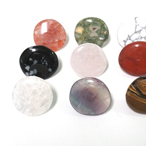 K&ouml;nnte beinhalten: Sortiment aus zehn glatten, runden, polierten Steinen in verschiedenen Farben und Mustern, darunter Rot, Gr&uuml;n, Wei&szlig;, Schwarz, Rosa, Lila und Braun.