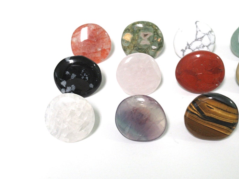 K&ouml;nnte beinhalten: Sortiment aus zehn glatten, runden, polierten Steinen in verschiedenen Farben und Mustern, darunter Rot, Gr&uuml;n, Wei&szlig;, Schwarz, Rosa, Lila und Braun.