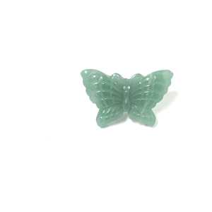 May include: A green gemstone butterfly charm. The butterfly is carved from a light green stone and has detailed wings.