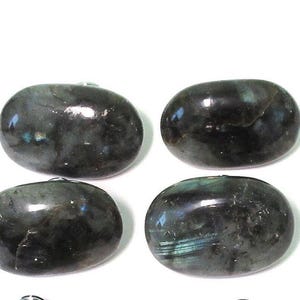 May include: Four polished, oval-shaped labradorite stones. The stones are a dark gray color with iridescent blue and green flashes. They are smooth and have a glossy finish, set against a white background.