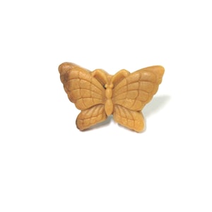 May include: A brown wooden butterfly shaped button.