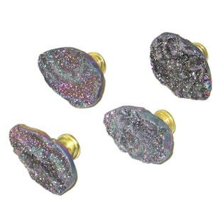 May include: Four iridescent purple and black crystal drawer pulls with gold metal bases.