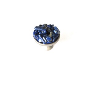 May include: A silver ring with a round bezel set with a cluster of small, blue lapis lazuli stones.