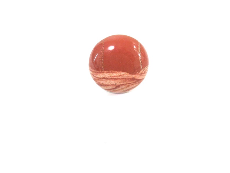 May include: A round, red and white stone with a swirling pattern. The stone is smooth and polished.