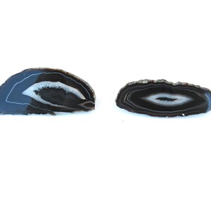 May include: Two agate slices, one half-circle and one oval, with black and white banding.
