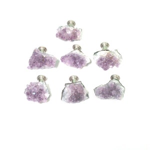 May include: Seven amethyst crystal cabinet knobs with silver metal bases. The amethyst crystals are a light purple color and have a rough, natural texture.