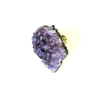 May include: A purple amethyst crystal knob with a gold metal base. The crystal is a cluster of many small crystals.