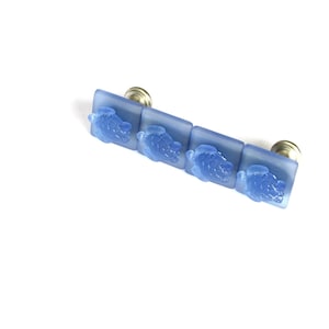 May include: A set of four blue glass cabinet knobs with a sea turtle design. Each knob has a silver metal base.