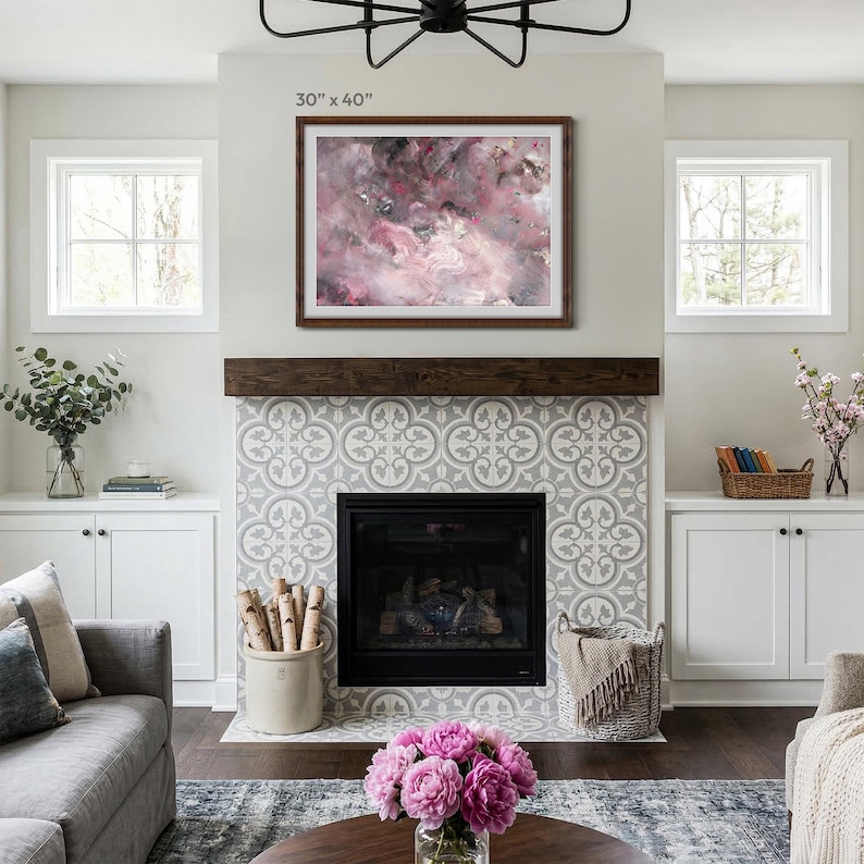 A large oversized 30x40 inch wooden picture frame with custom gray matting hanging above a modern fireplace in a bright living room. Perfect large custom wood frame for statement wall art and home decor.