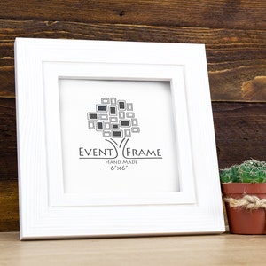May include: White picture frame with a double mat, featuring a logo that says "Event Frame" and "Hand Made 6"x"6".