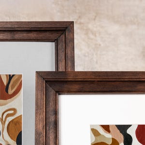 Detailed corner close-up of two overlapping solid birch wood frames. Showcases the elegant contrast between a custom gray mat board and a crisp custom white photo mat inside dark wood molding.