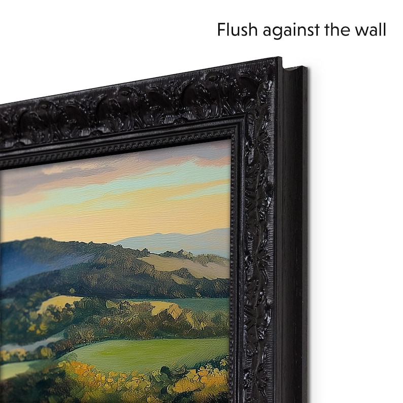 May include: A black framed landscape painting of a green valley with hills in the distance. The painting is framed with a decorative black frame with a raised edge. The text "Flush against the wall" is visible in the upper right corner of the image.