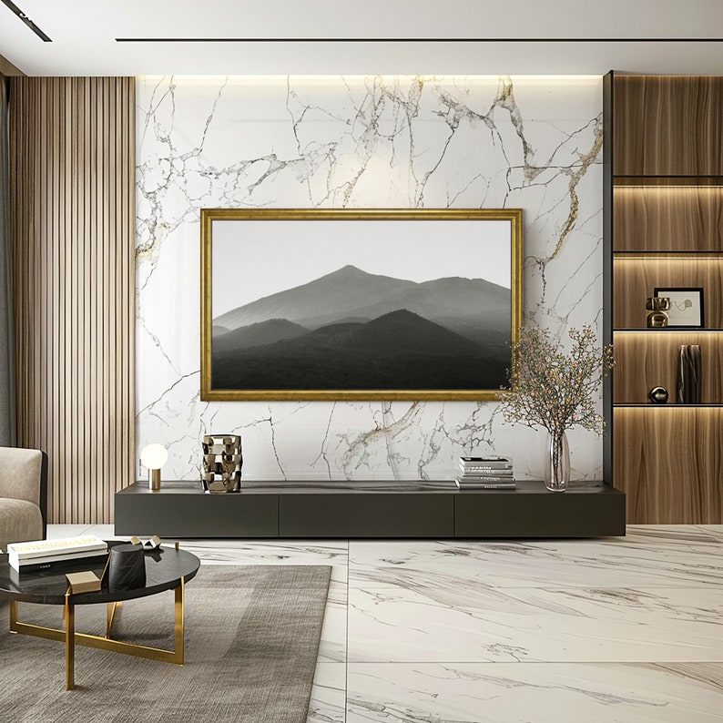 Samsung wood frame tv with golden coating in modern living room with marble panel walls and gold accents, black and white mountain art